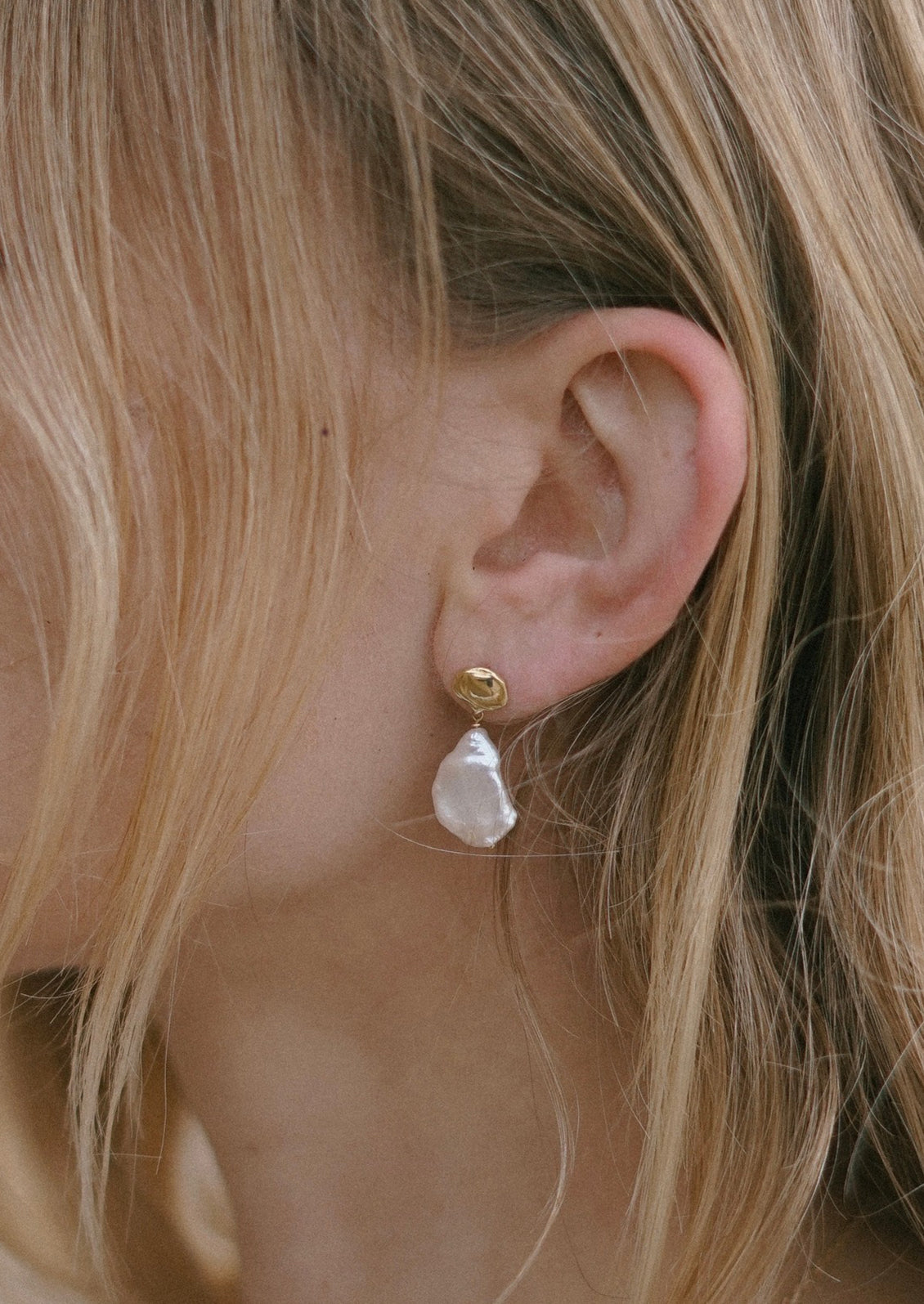 A pair of baroque pearl and brass earrings.