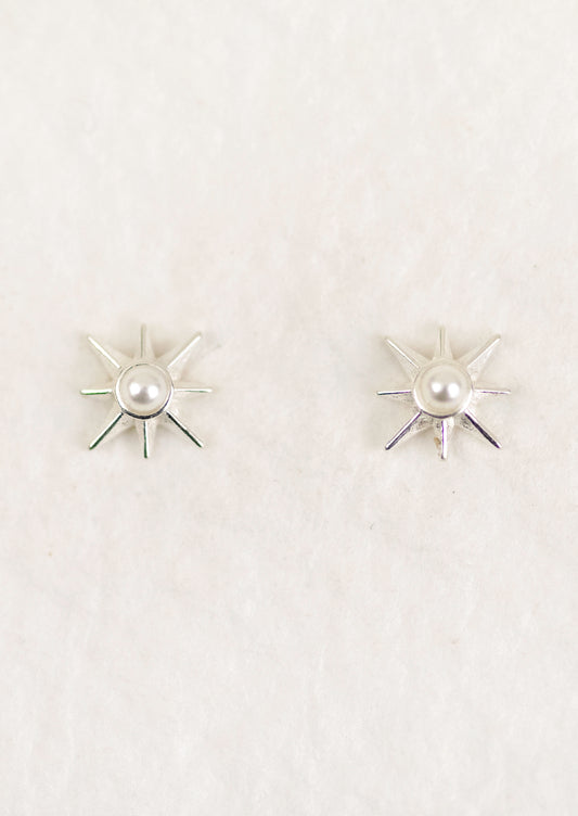 A pair of sterling silver starburst earrings with a pearl center.