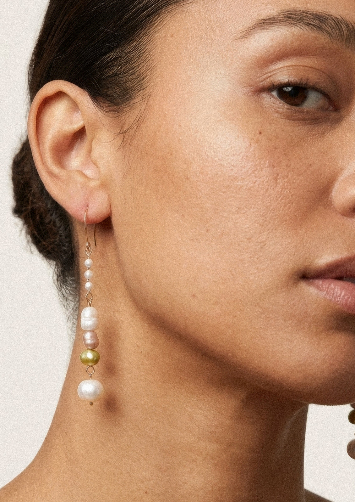 A pair of dangling earrings with freshwater pearls and faux pearls.