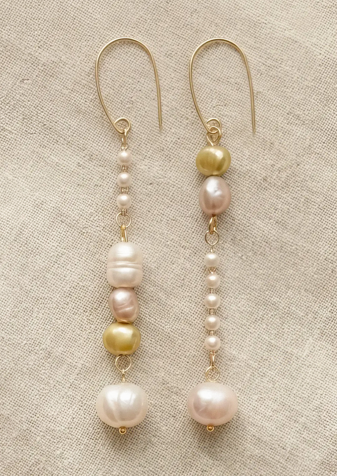 A pair of dangling earrings with freshwater pearls and faux pearls.