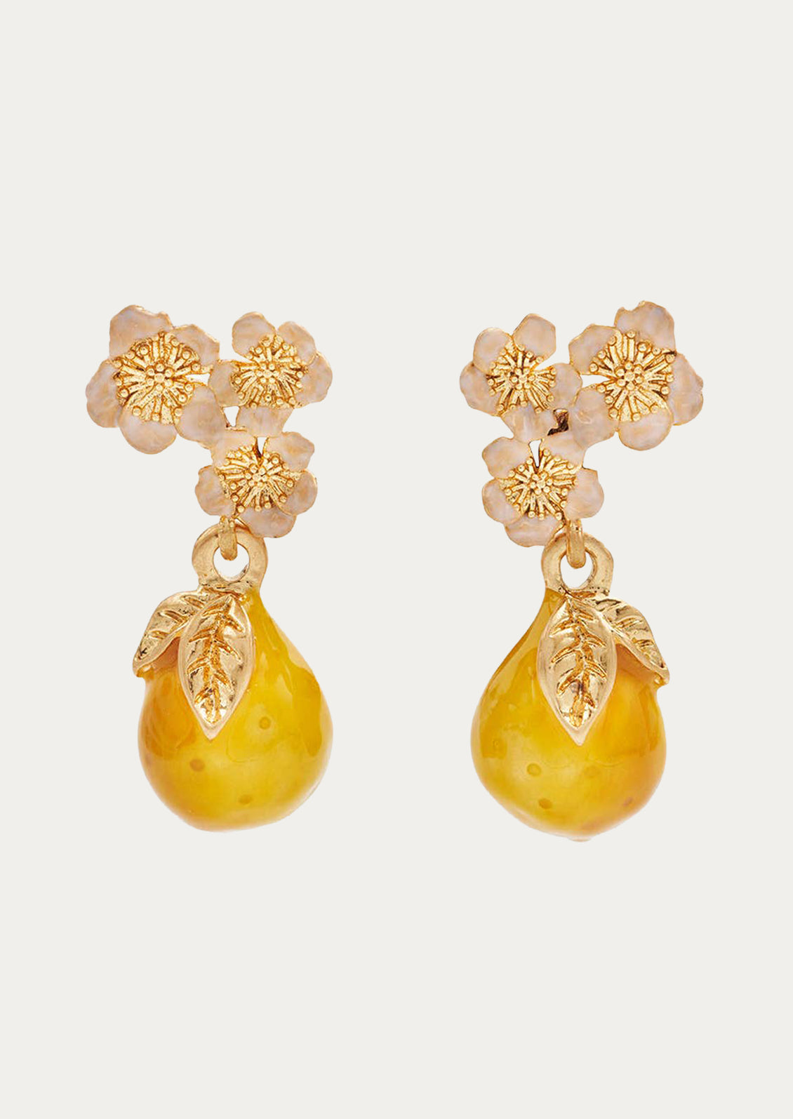 A pair of golden pear drop earrings adorned with light pink flowers.