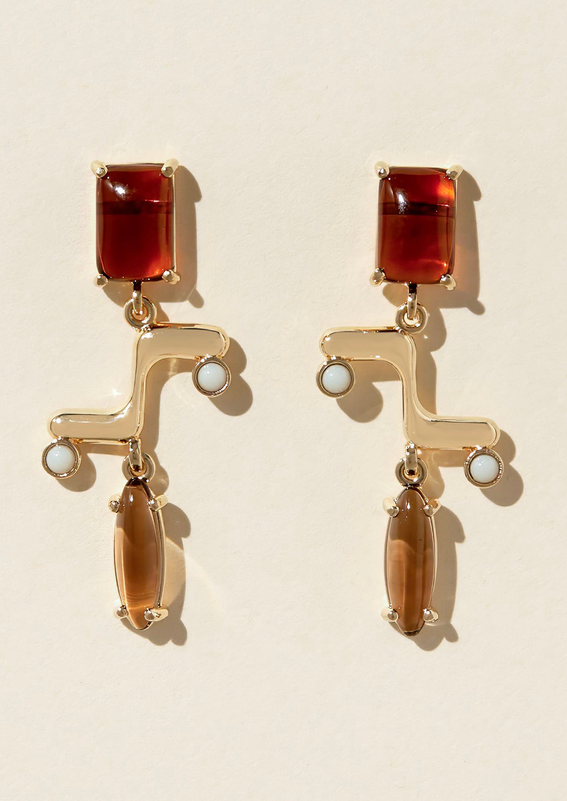 A pair of drop earrings with colored cabochons.