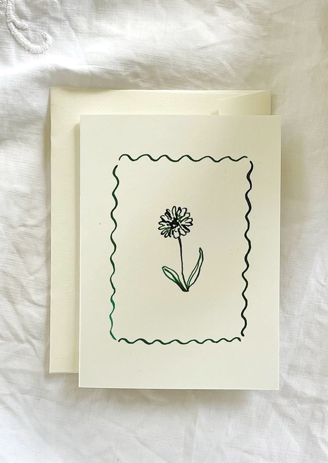 A card with framed floral illustration in green ink.