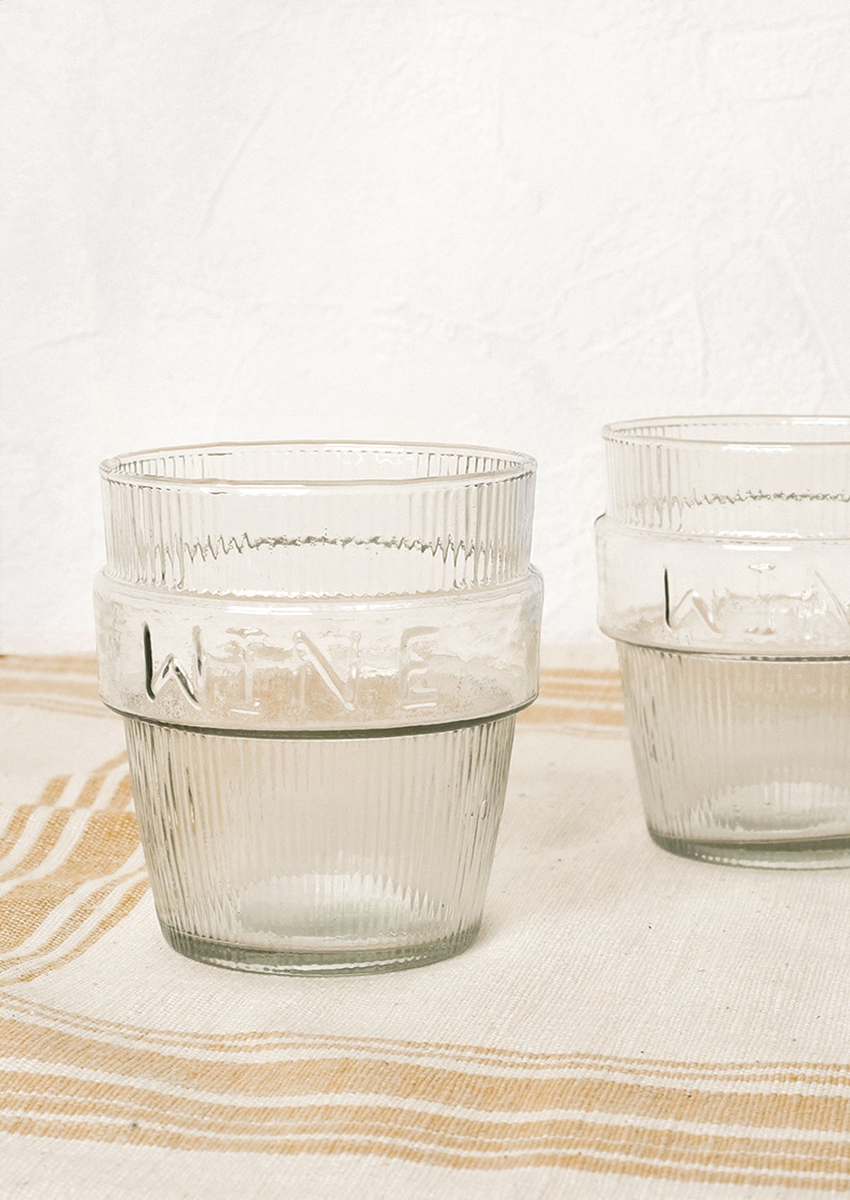 Two short ribbed clear glasses labeled "wine".
