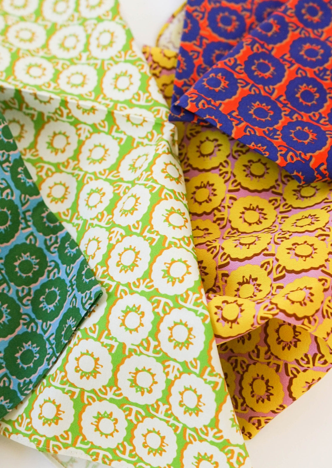 A set of four different brightly colored napkins in floral pattern.