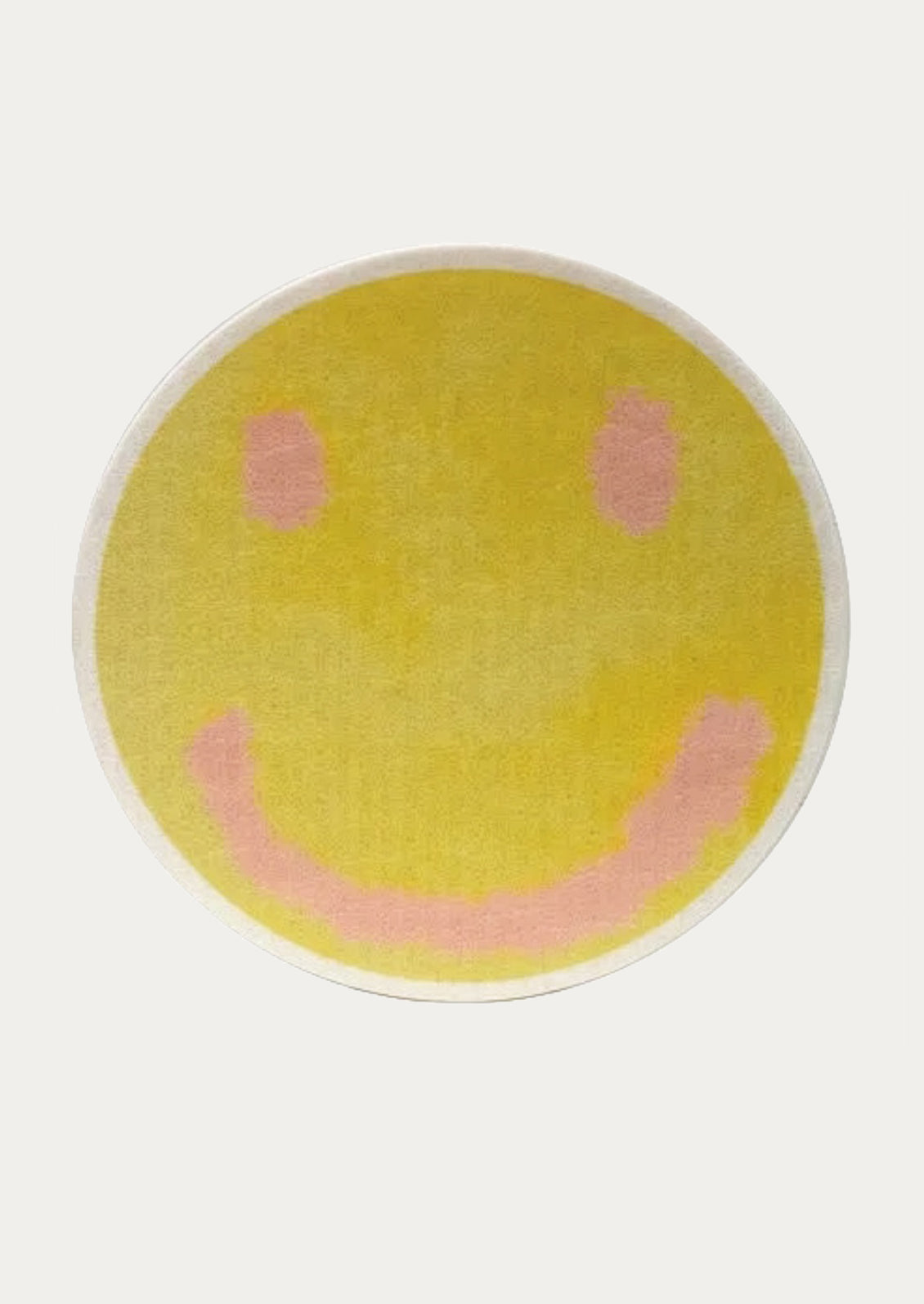 Round yellow sponge with a smiley face design on a white background