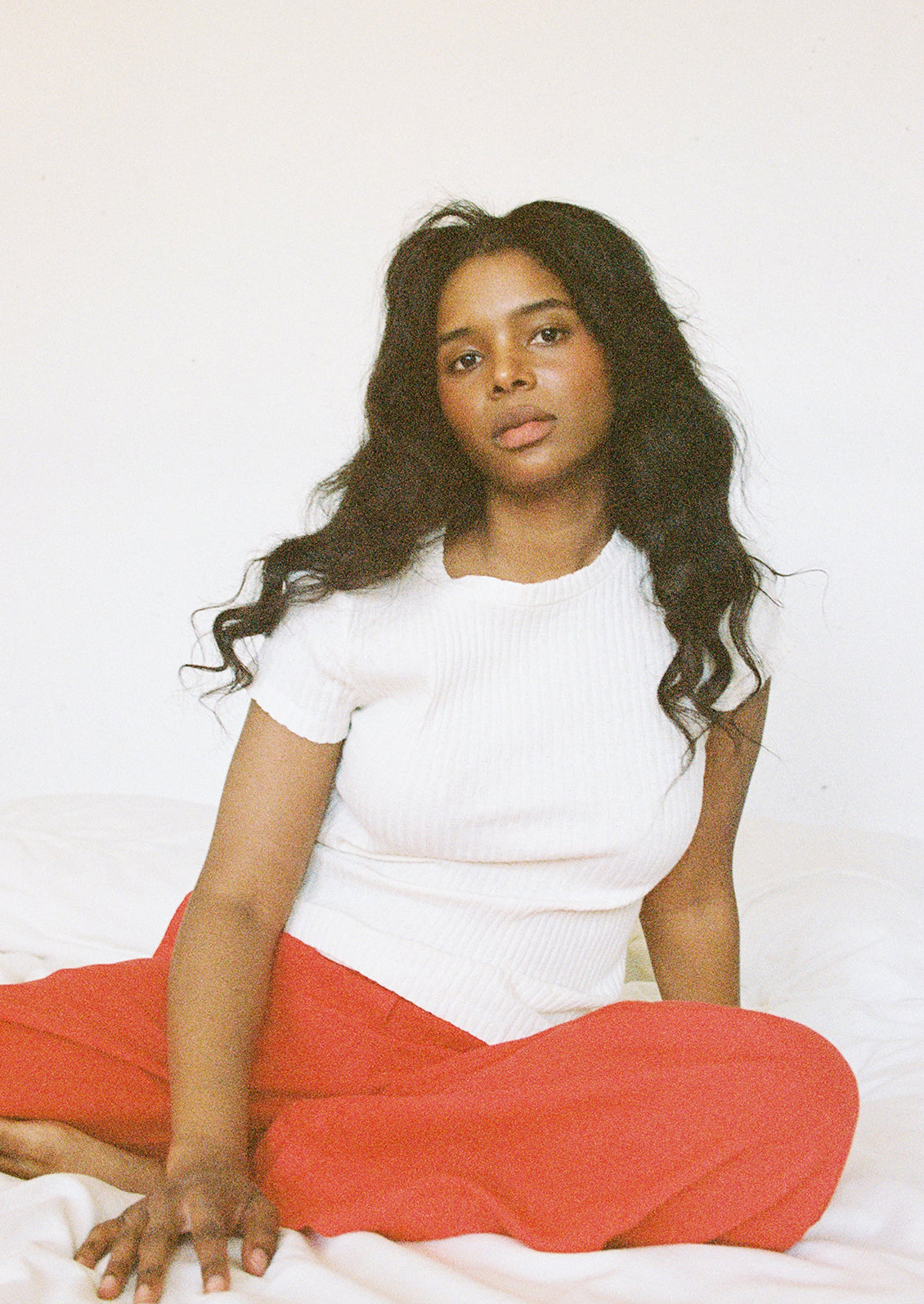 A woman wearing a cream colored pointelle short sleeve tee.