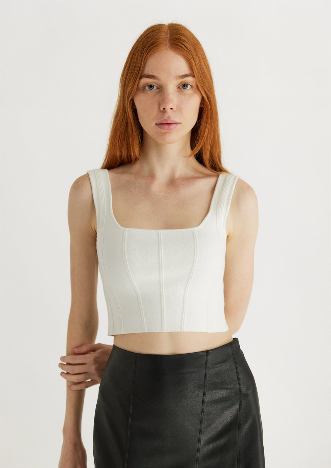 Woman wearing white knit cropped tank. 