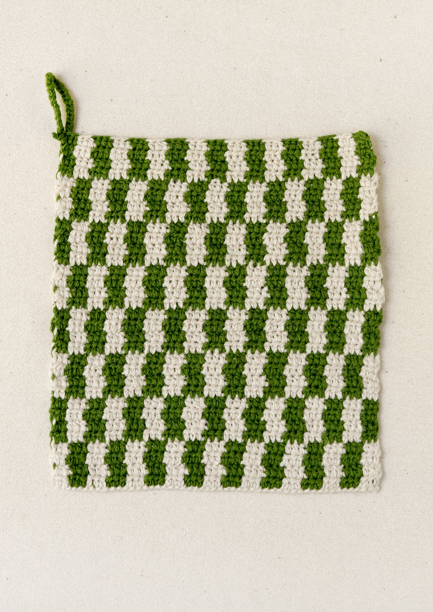 A green plaid crocheted potholder.