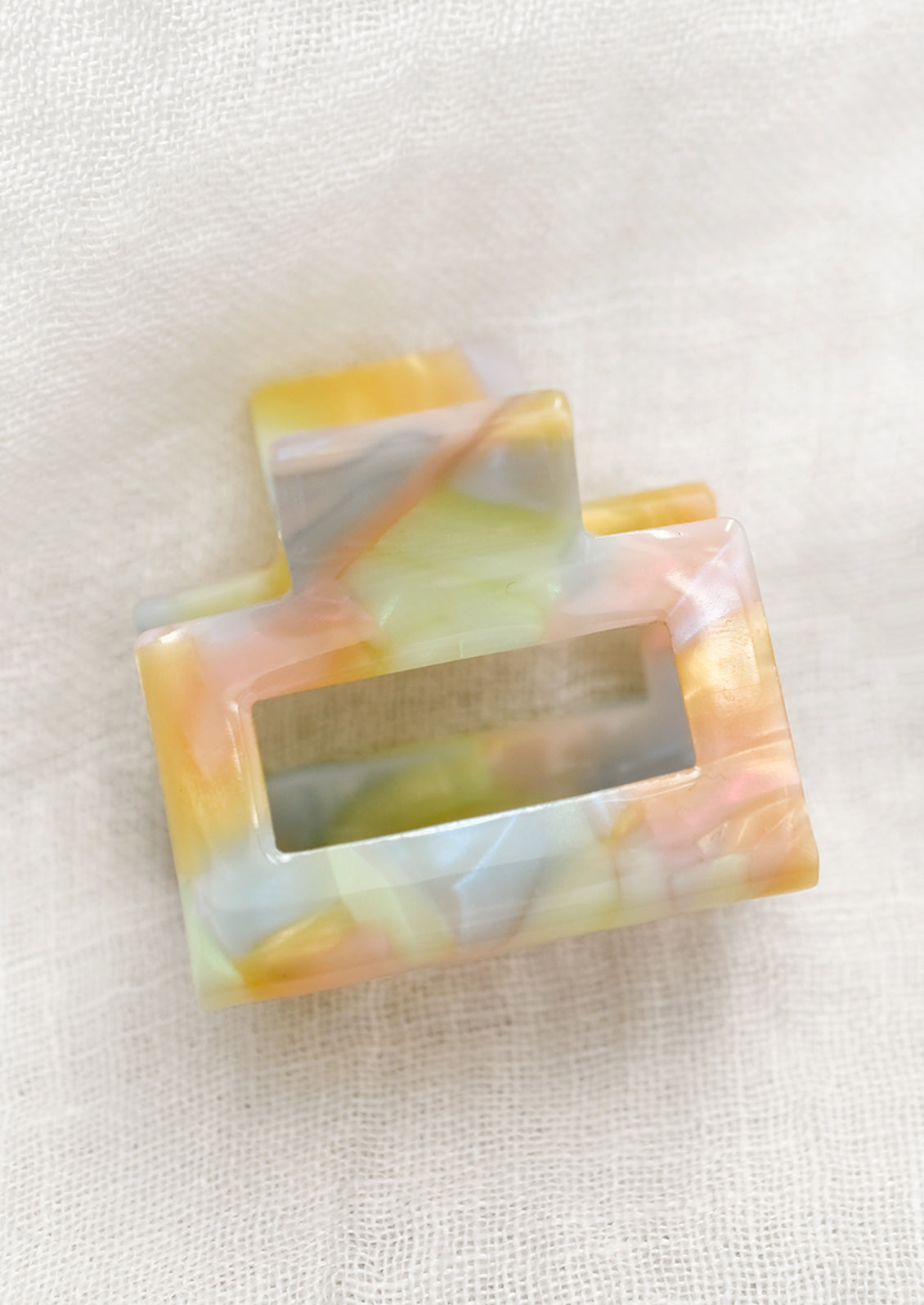 A small hair claw in pastel, prismatic colors.