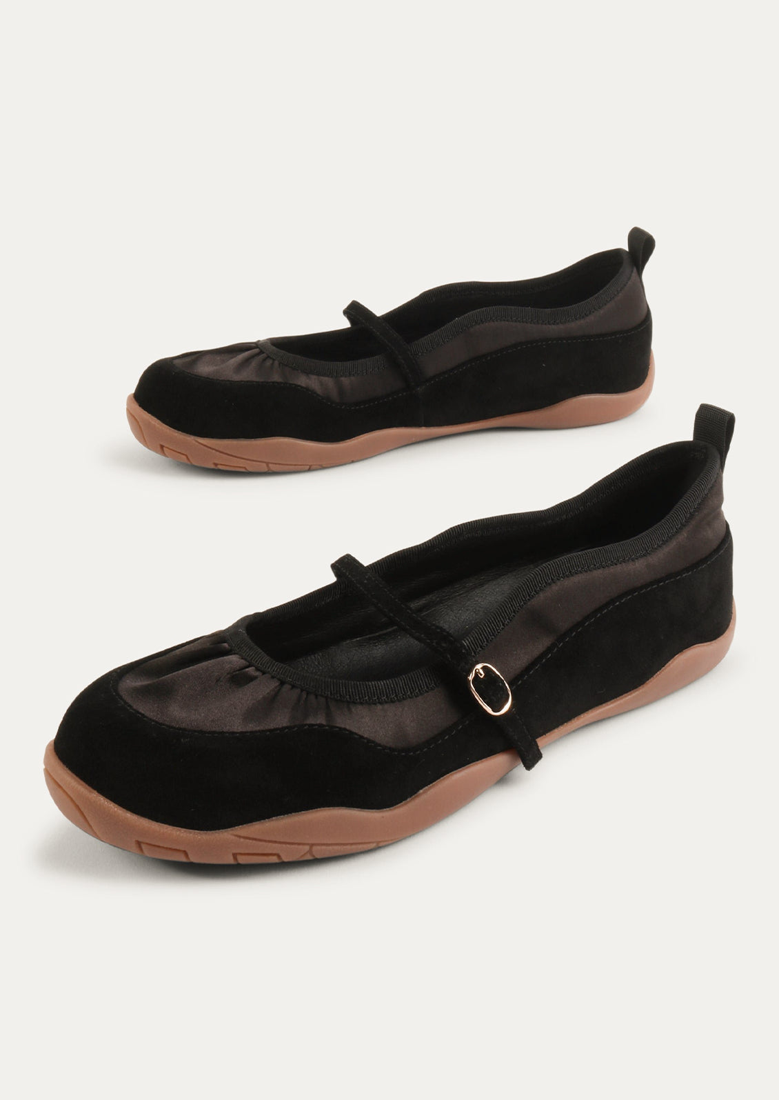 A pair of black shoes that are part sneaker, part ballet flat mary jane. Suede/textile upper with a rubber gum sole.