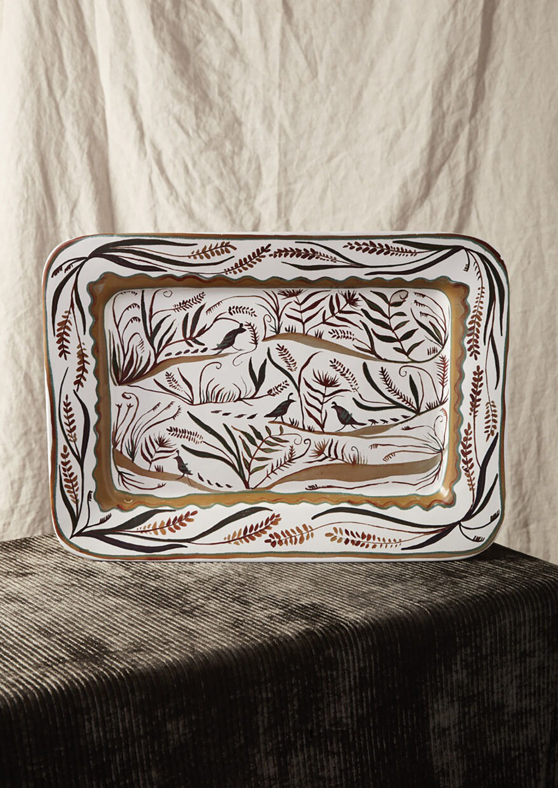A rectangular ceramic platter with quail and nature pattern in brown.