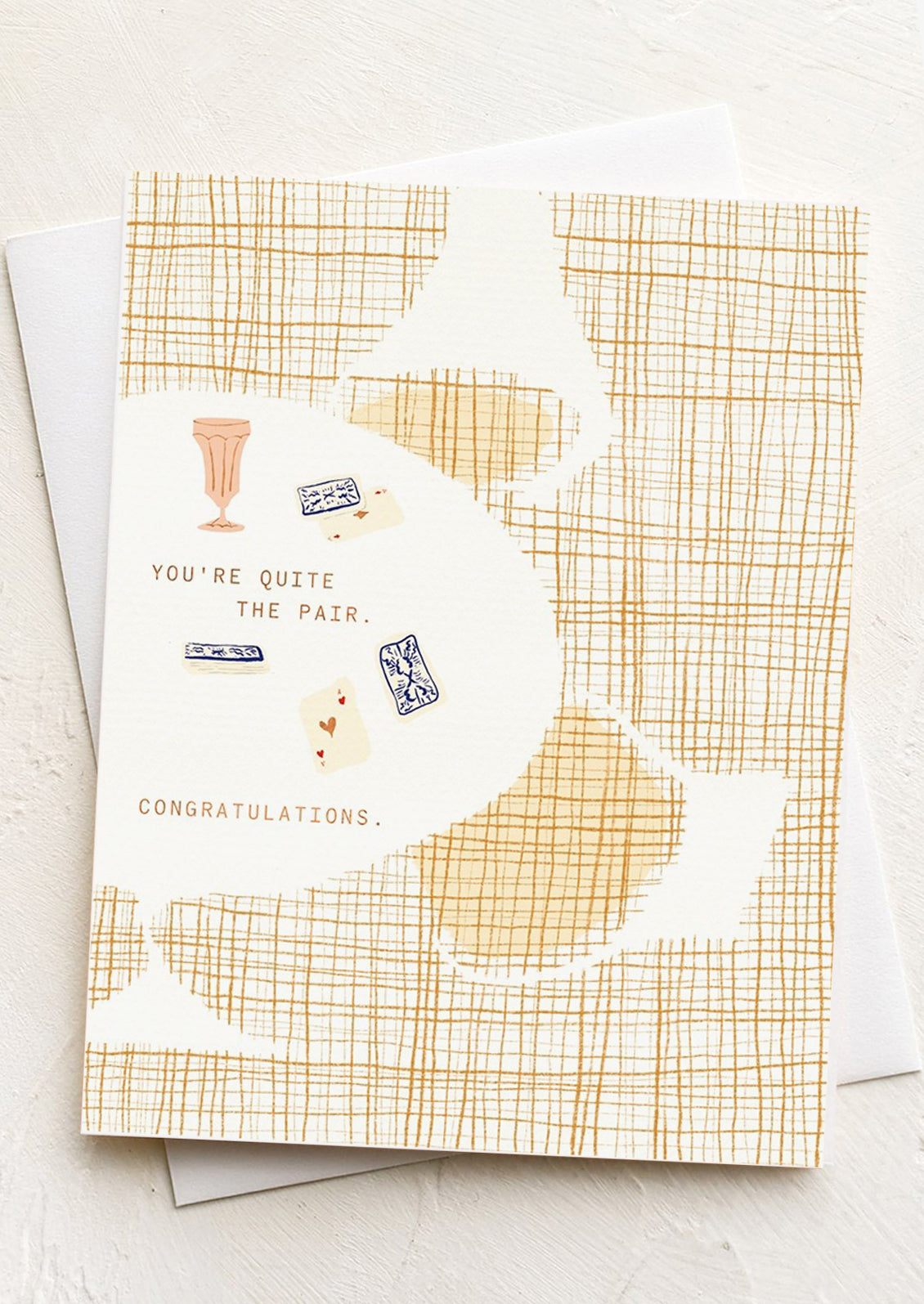 A card with illustration of playing cards on a table ,text reads "You're Quite The Pair. Congratulations".