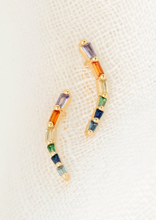 Multicolored beaded earrings on a textured beige surface
