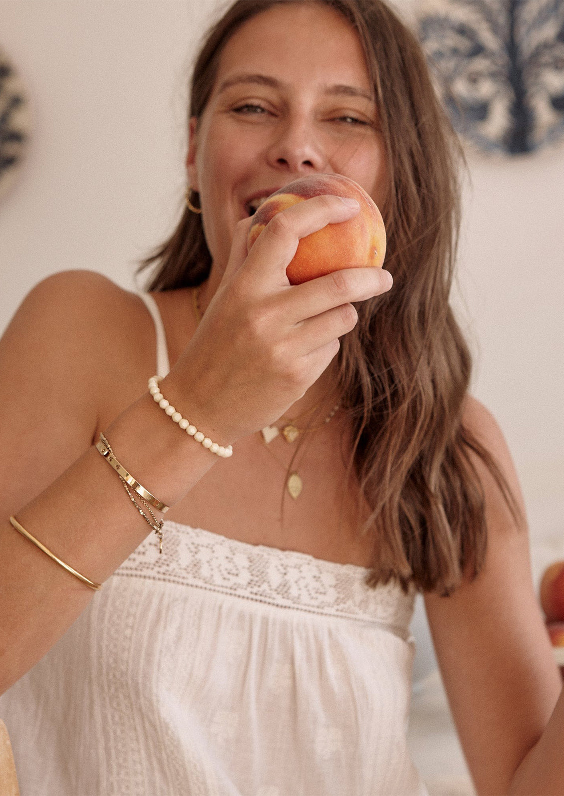 A woman wearing a square neck cami tank top in white with tonal embroidery.