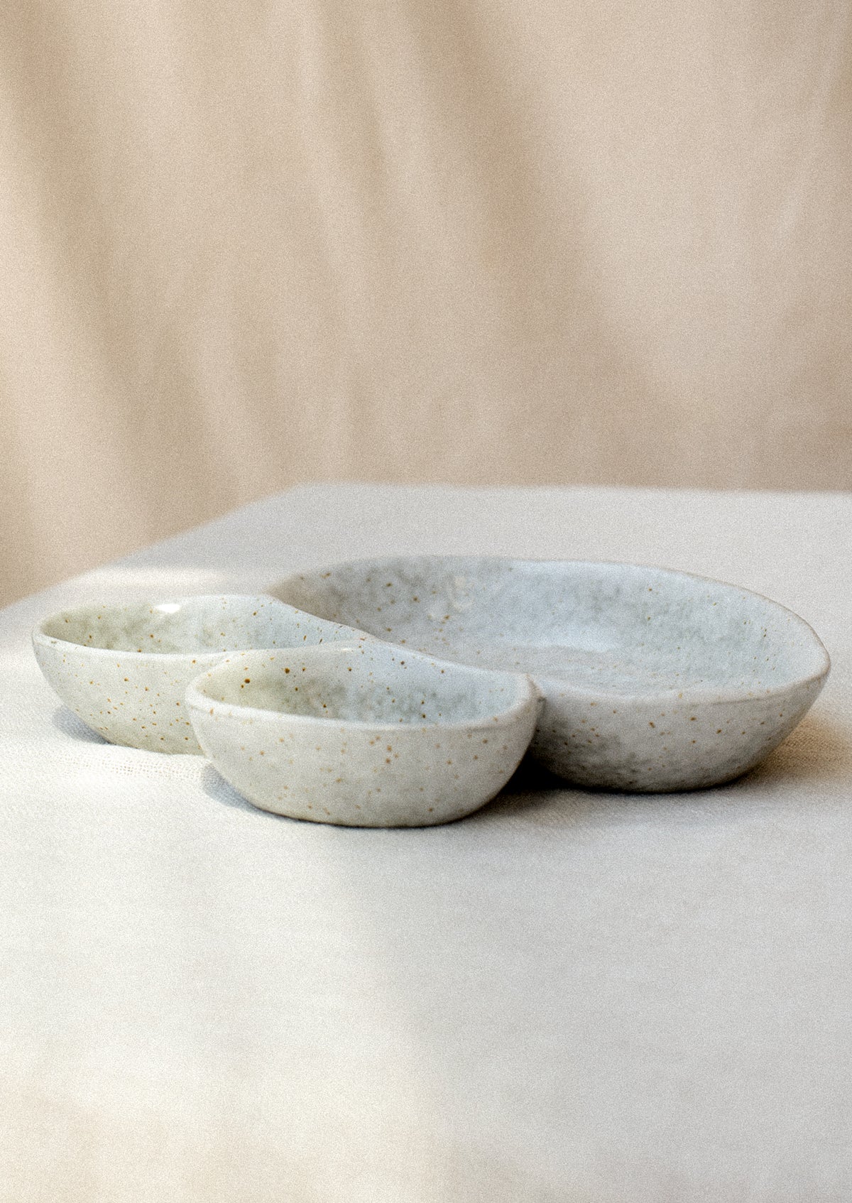 Divided dish with three asymmetrical sections in speckled grey ceramic.