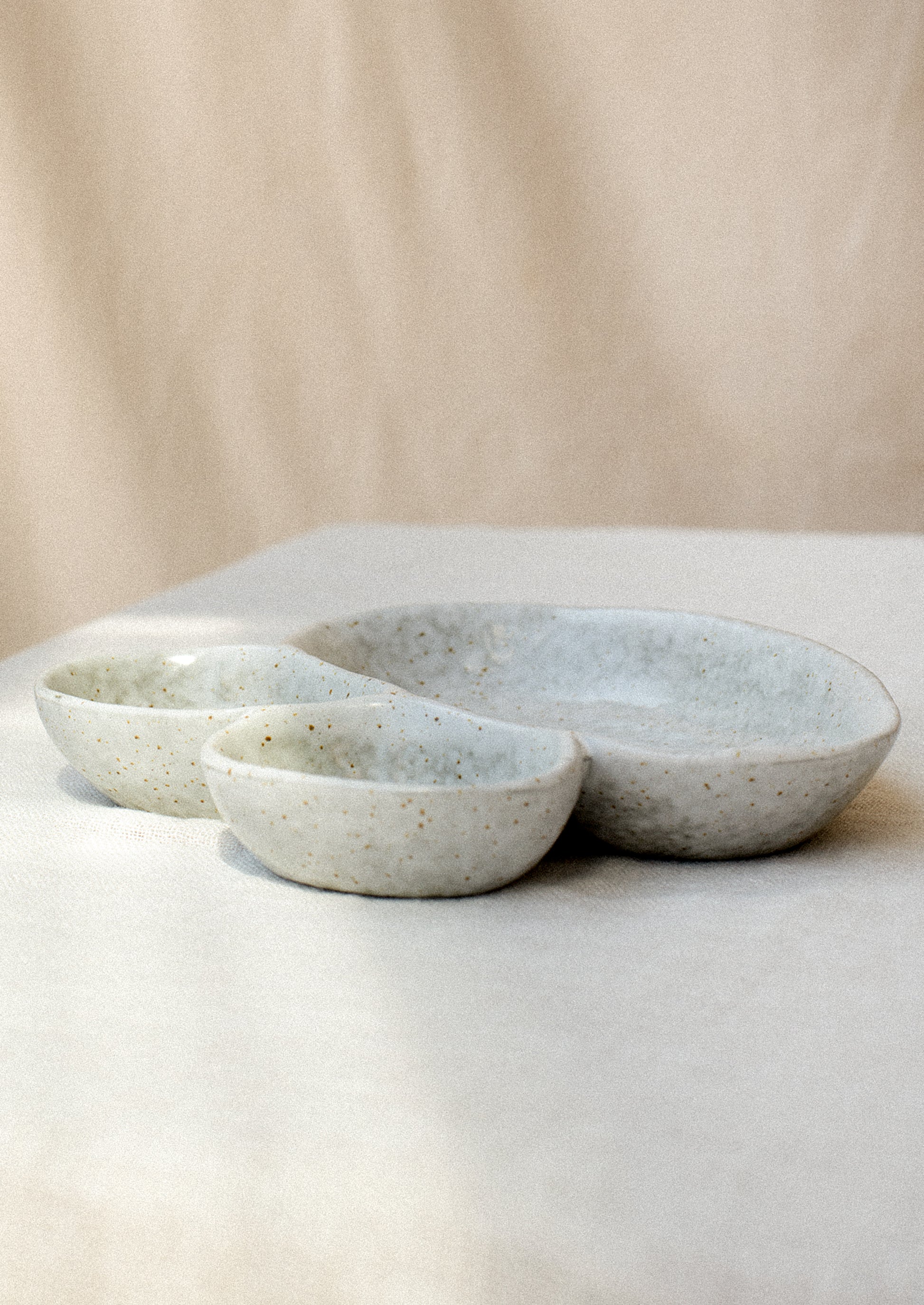 Divided dish with three asymmetrical sections in speckled grey ceramic.
