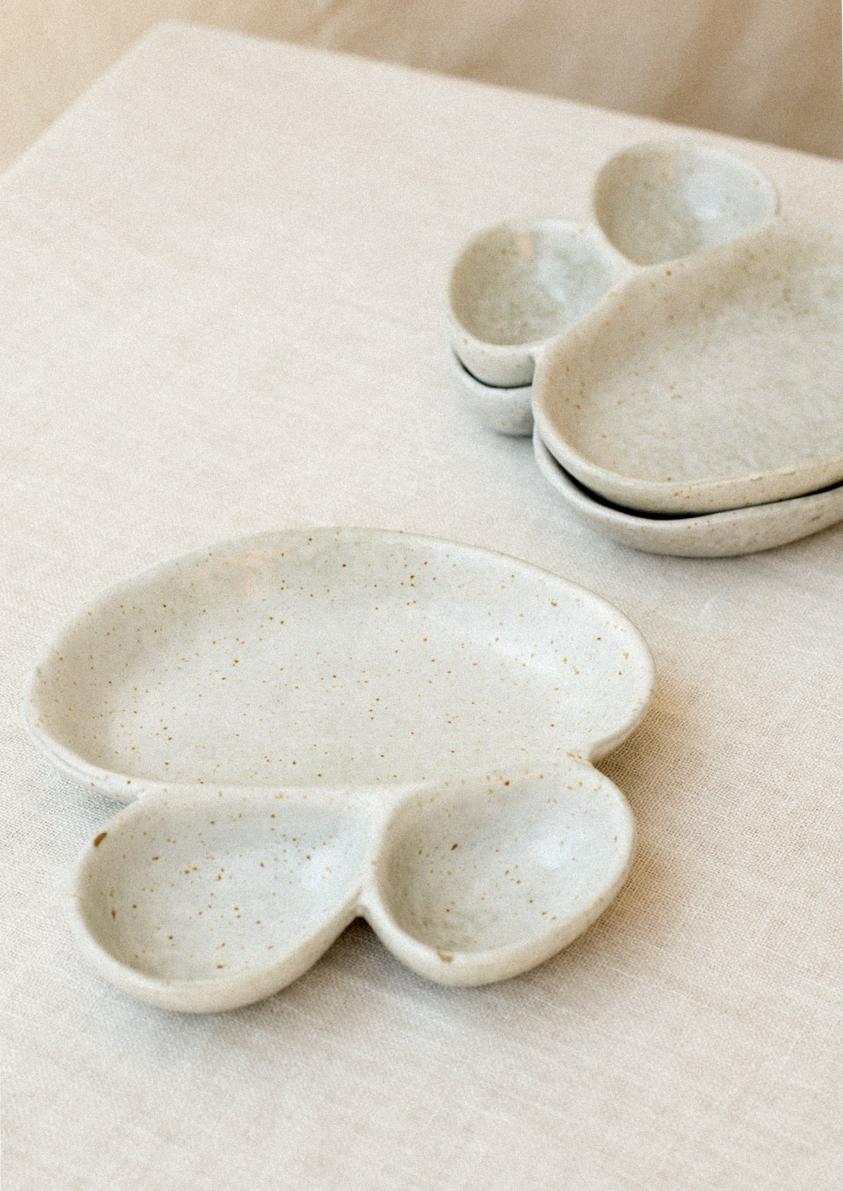 Divided dish with three asymmetrical sections in speckled grey ceramic.