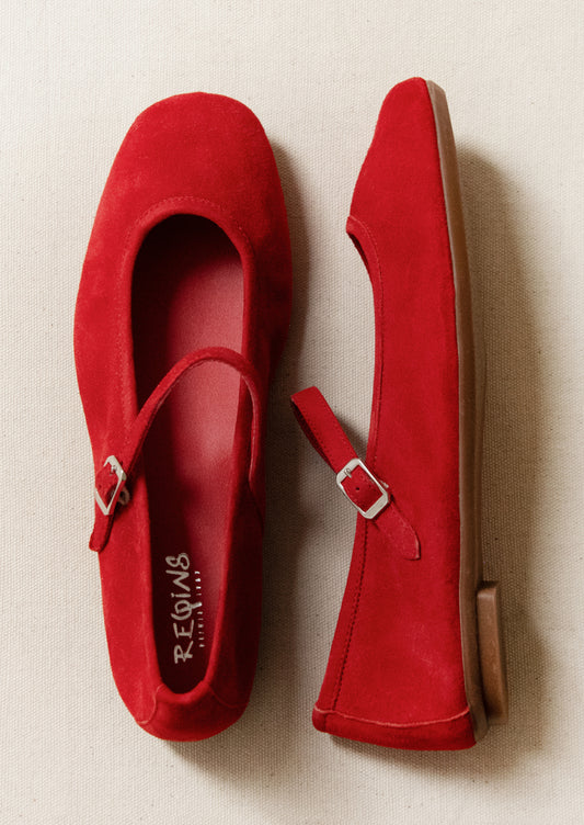 Red suede shoes with a buckle on a beige background