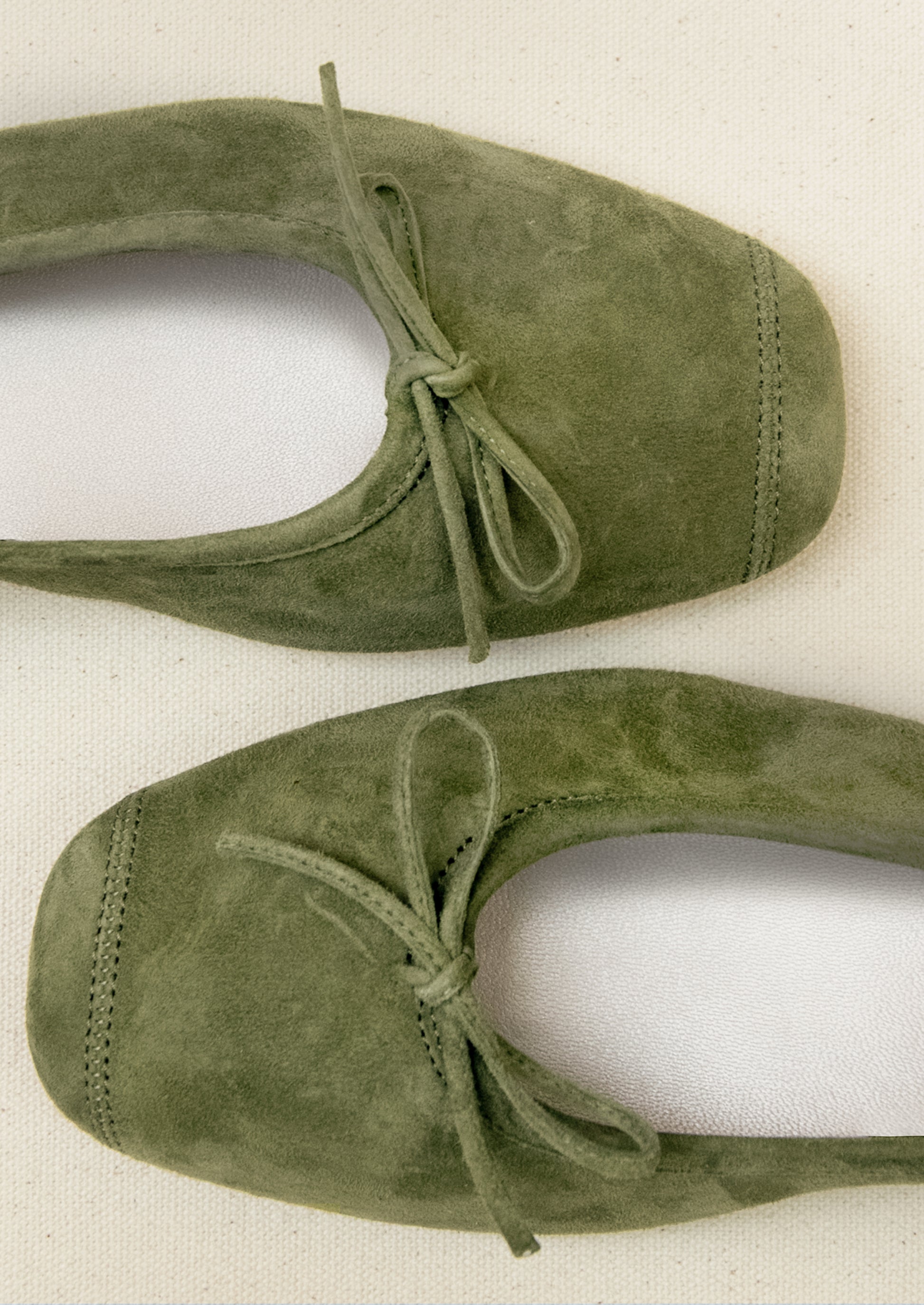 A pair of suede ballet flats in moss green.