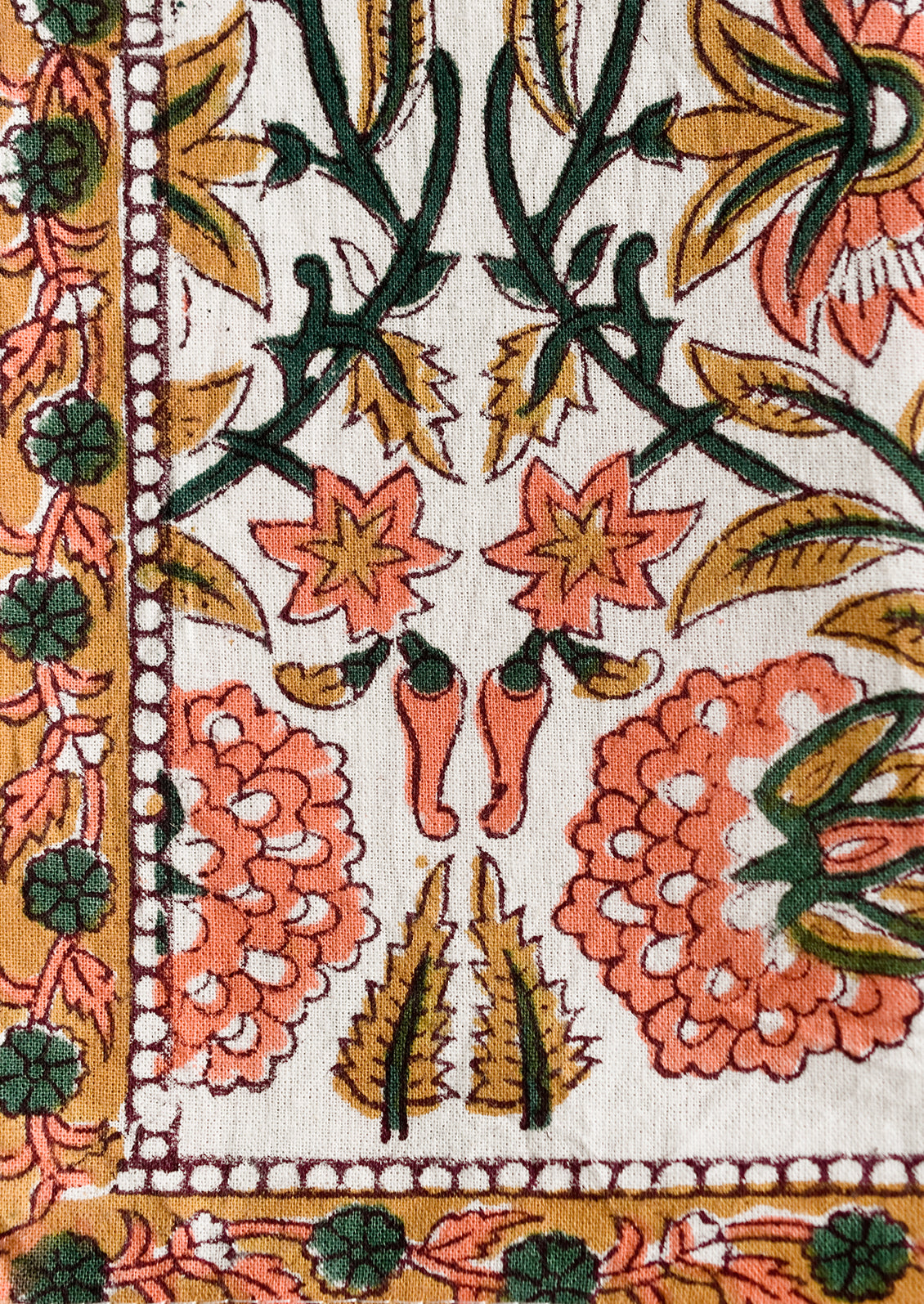 A set of two block printed napkins in pink, emerald and brown print.