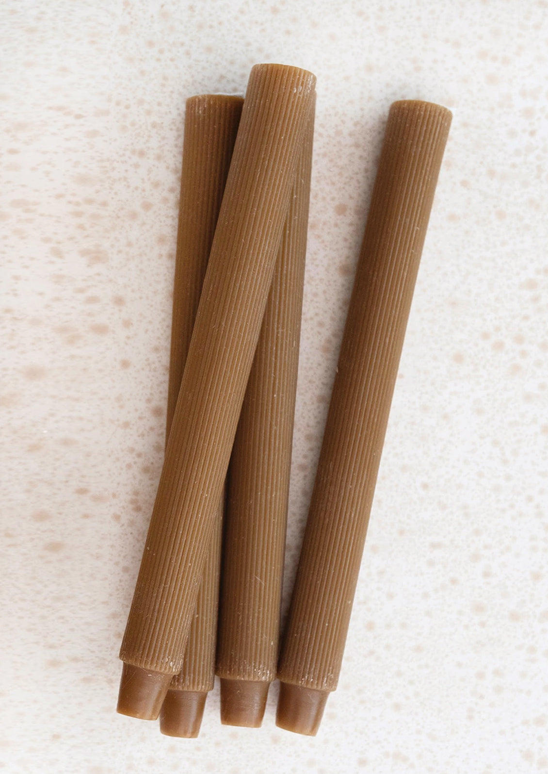 Taper candles with fine ribbed texture in cider brown.