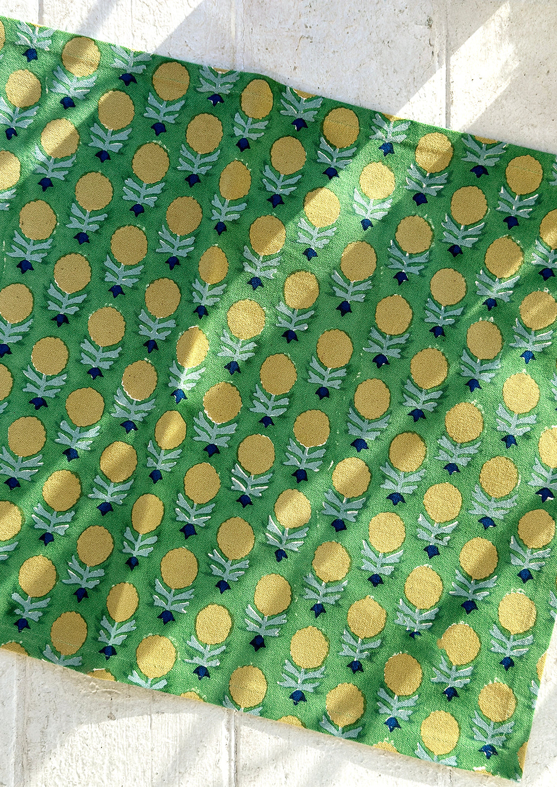 A green and yellow floral block print placemat.