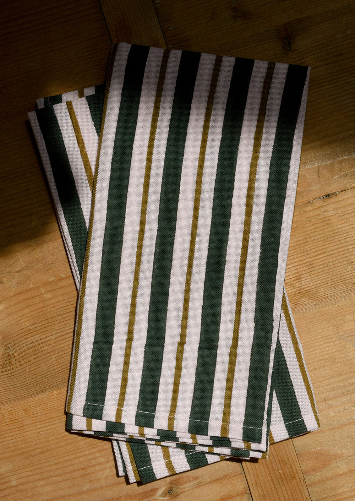 A pair of cotton napkins in pink and emerald green stripe.