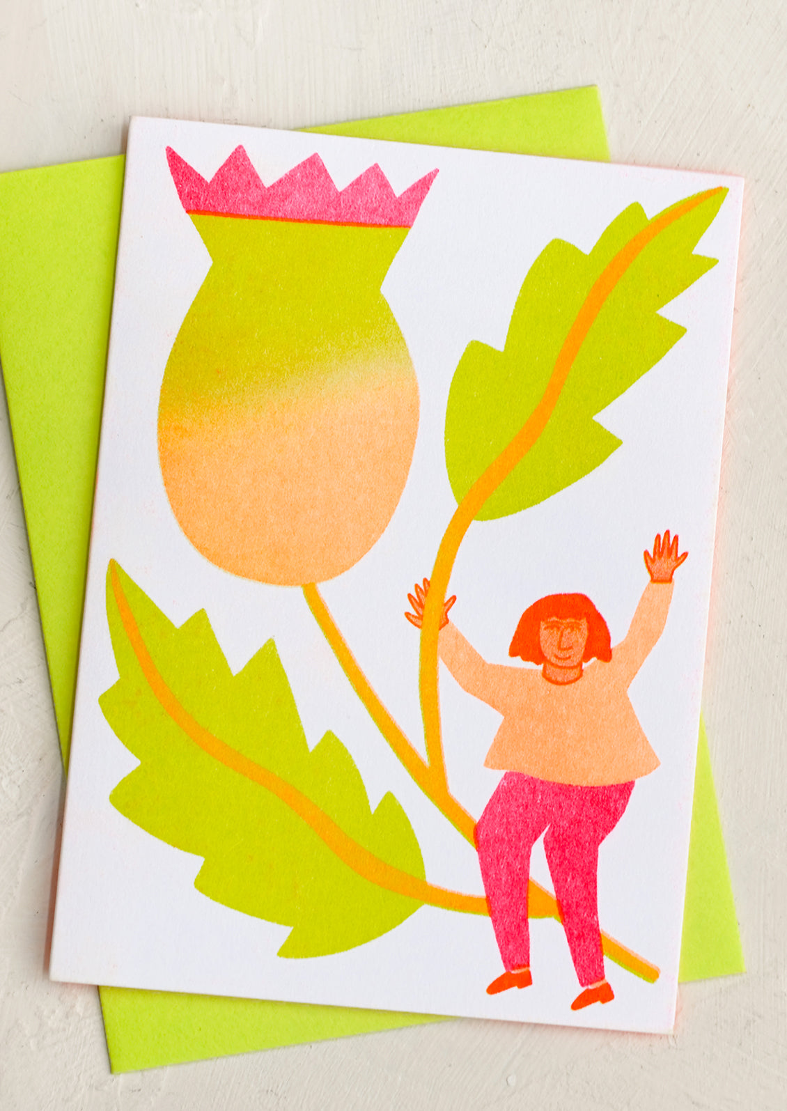 A risograph neon printed card with image of girl holding giant thistle flower.