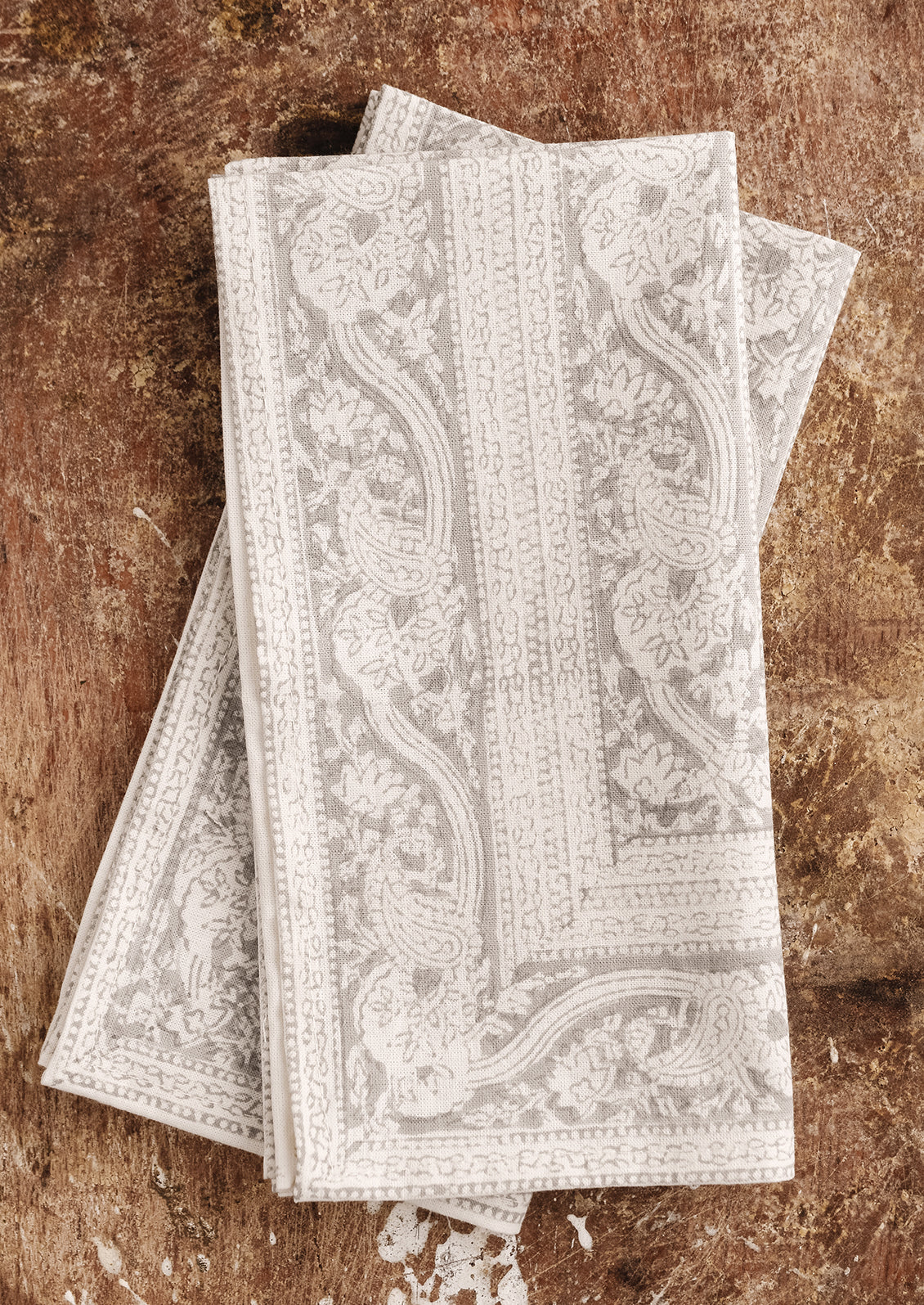 A pair of cotton dinner napkins in grey block print paisley.