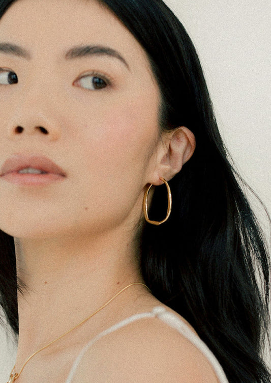 A pair of large gold hoop earrings.