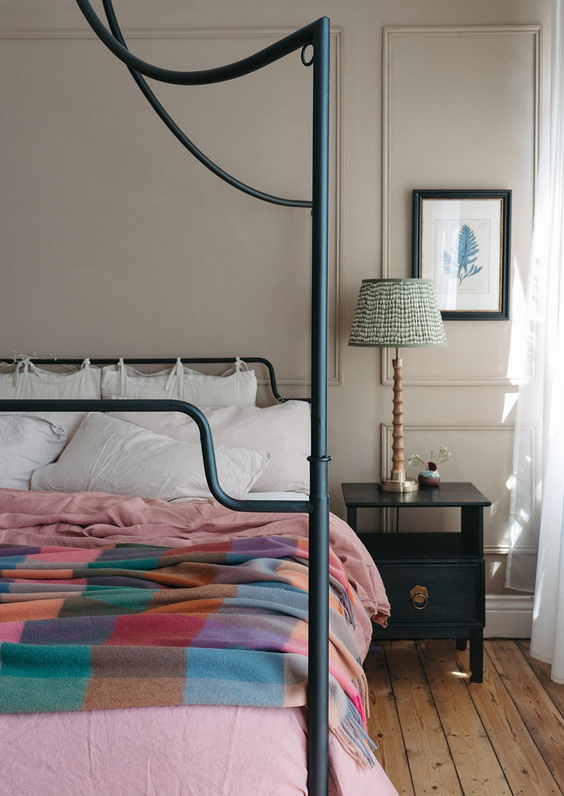 A madras check print wool throw in shades of peach, pink, teal, orange and blue.