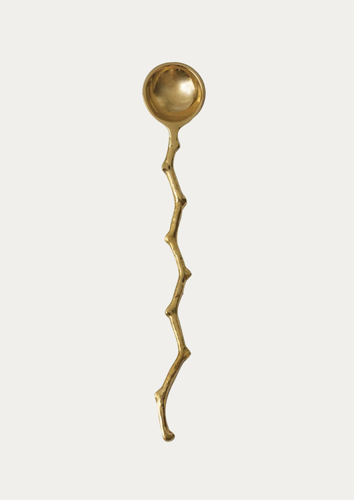 A brass spoon with twig-cast handle.
