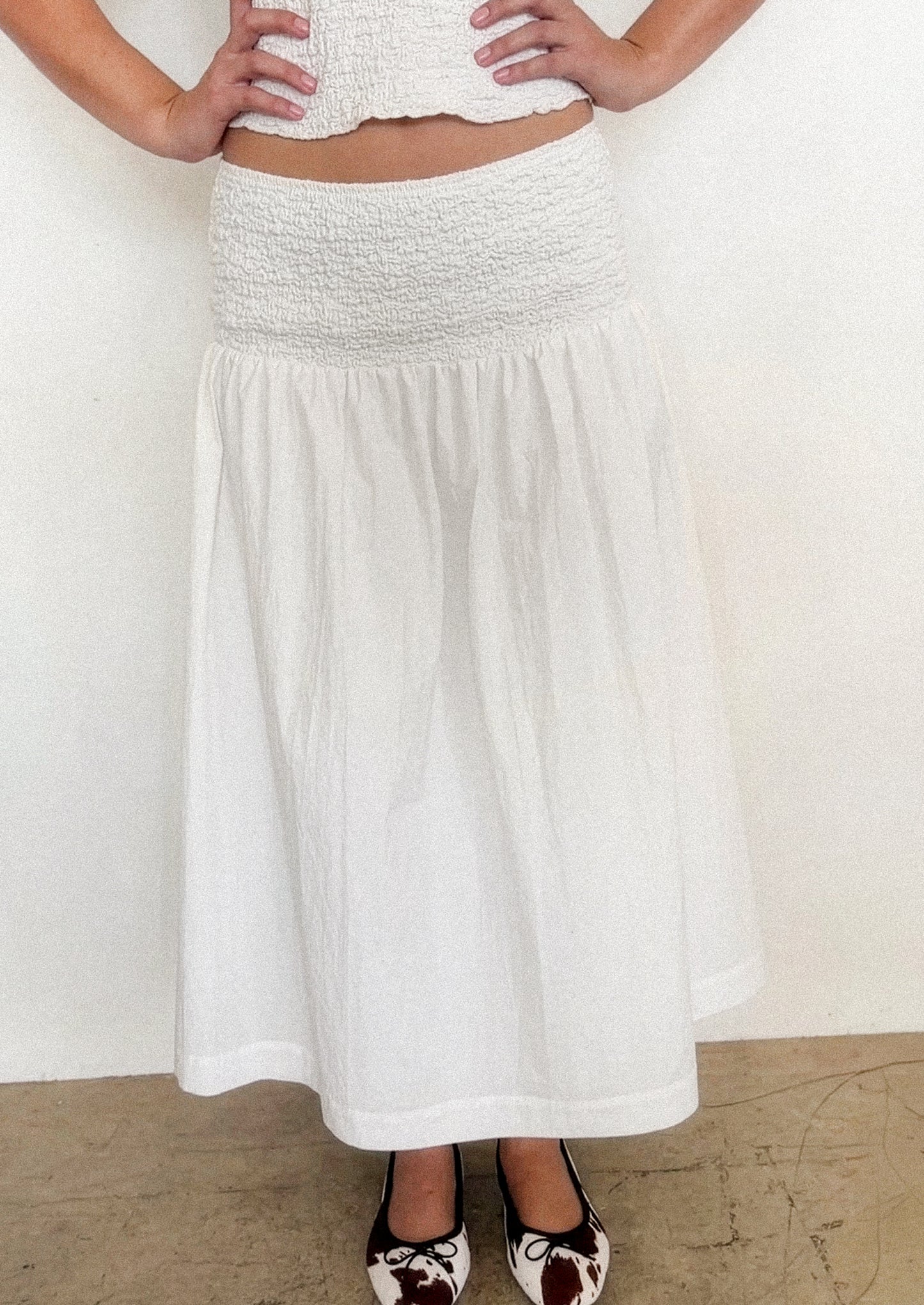 A person wearing a white midi skirt.