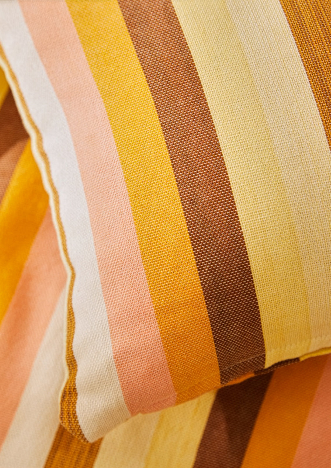 Close-up of a fabric with multicolored stripes in shades of orange, yellow, and brown.