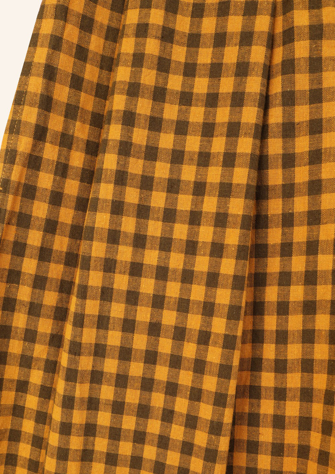 A pair of long, pleat front shorts in brown and mustard gingham.