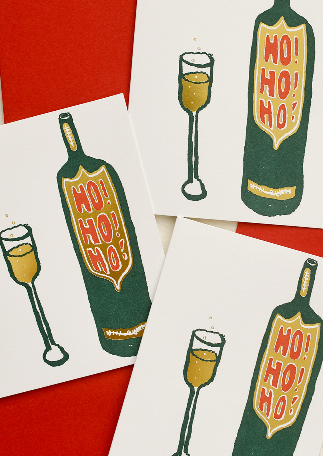 A greeting card with illustration of glass of champange next to bottle, text on bottle reads "Ho Ho Ho!".