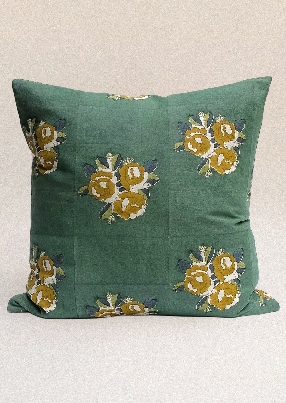 A block printed throw pillow in forest green with ochre floral print.
