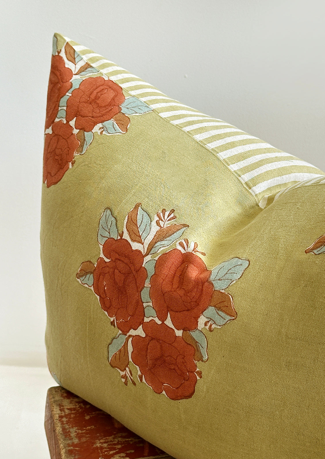 A printed throw pillow with striped back.