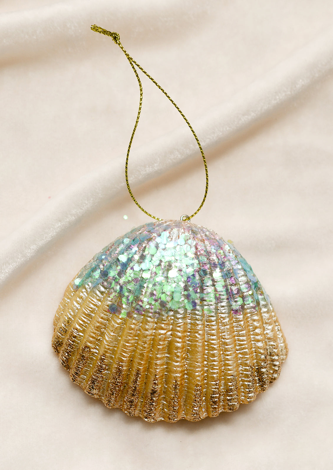 A scallop shell ornament with pearlescent finish.