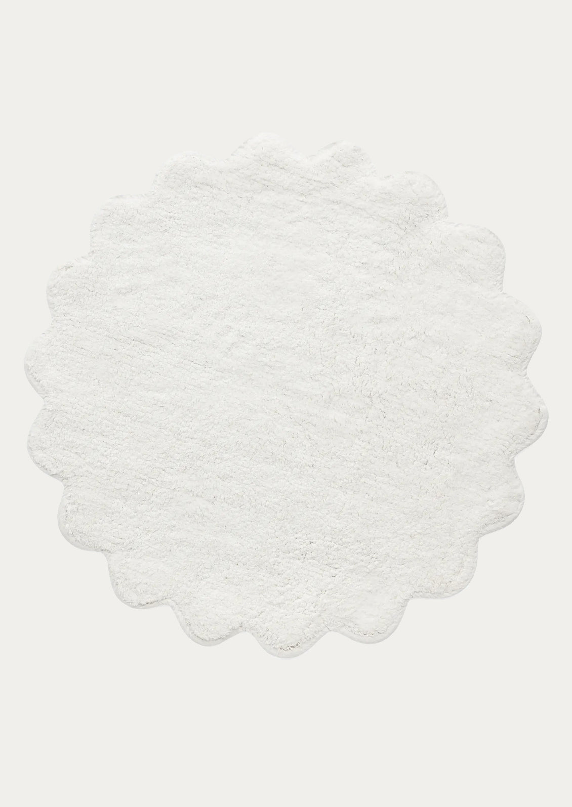 A round bathmat with scalloped edges in white.