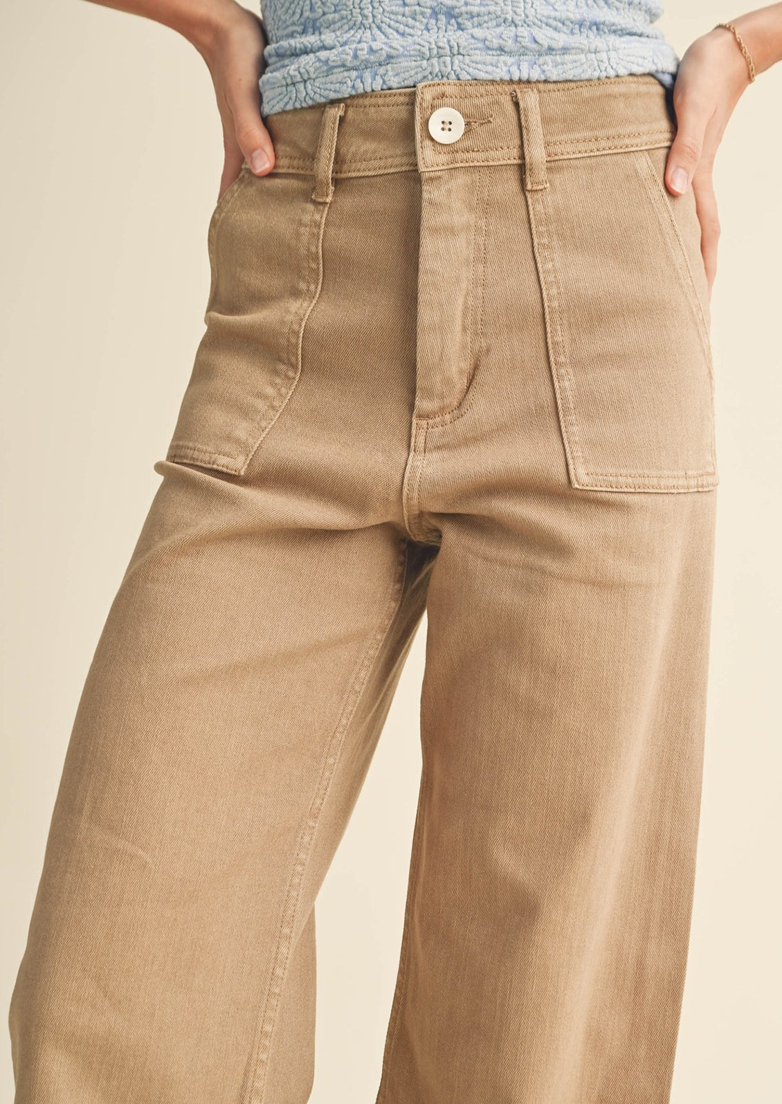 A pair of light brown wide leg pants with front patch pockets.