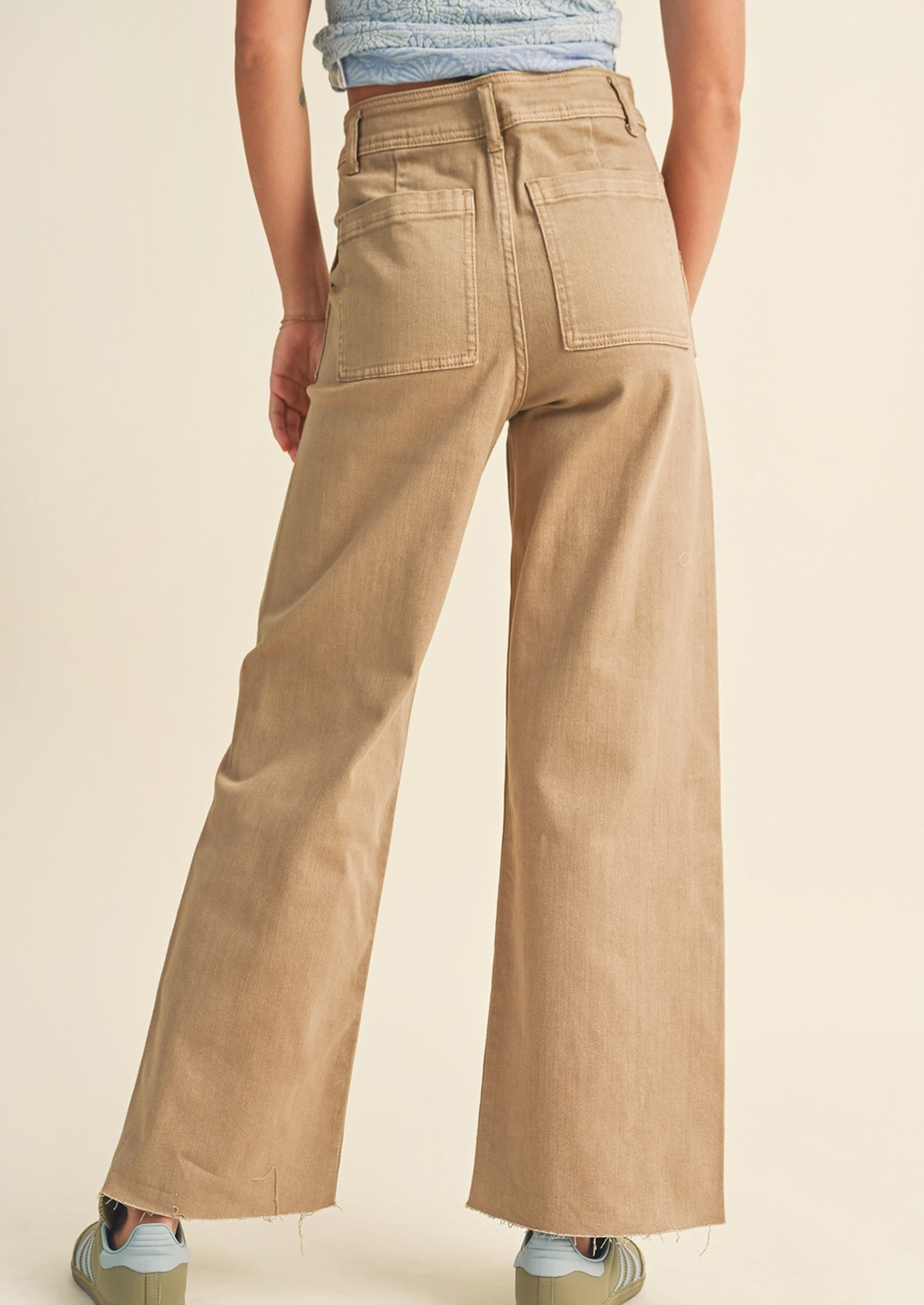 A pair of light brown wide leg pants with back patch pockets.