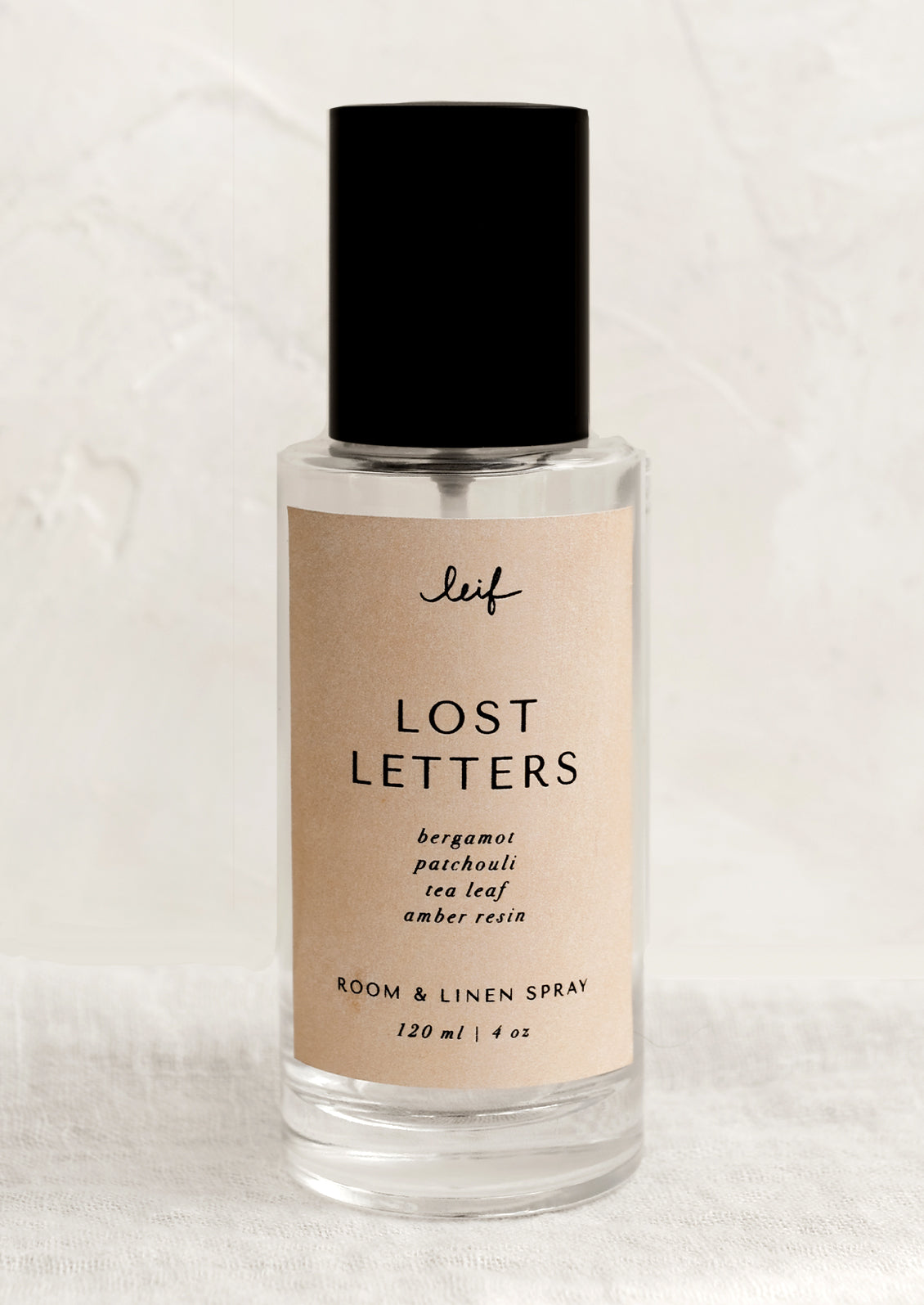 A room spray bottle with printed text on beige label.