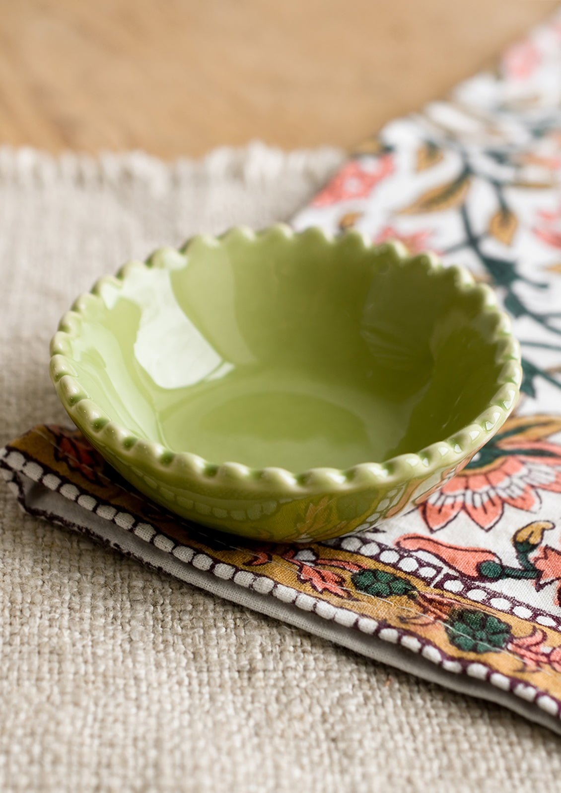 A small ceramic bowl with scalloped rim in green.