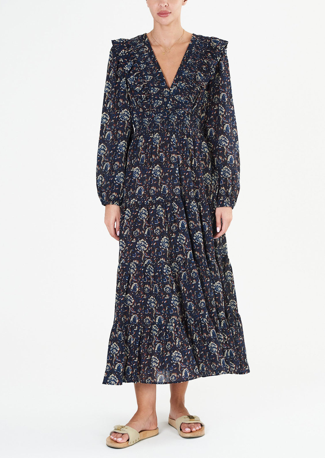 A long sleeve maxi dress with ruffled v-neck in black with blue, white and rust block print pattern.