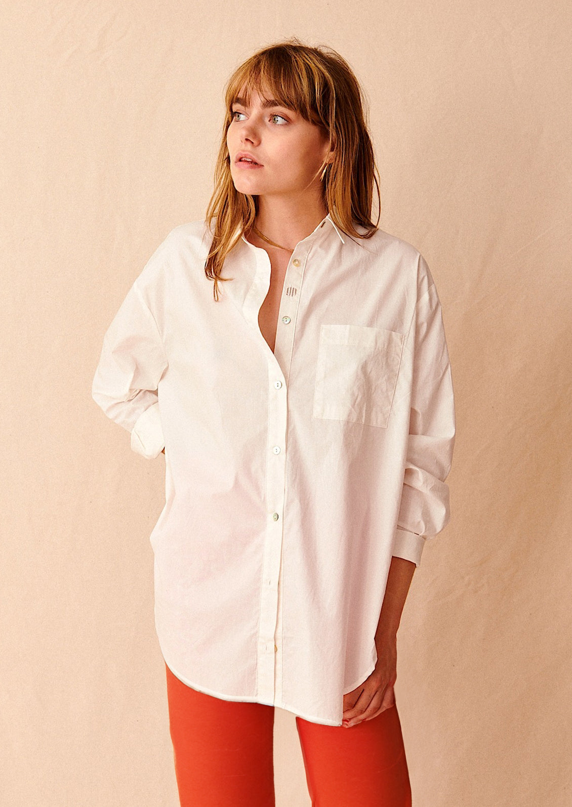 A woman wearing an oversized white cotton shirt.