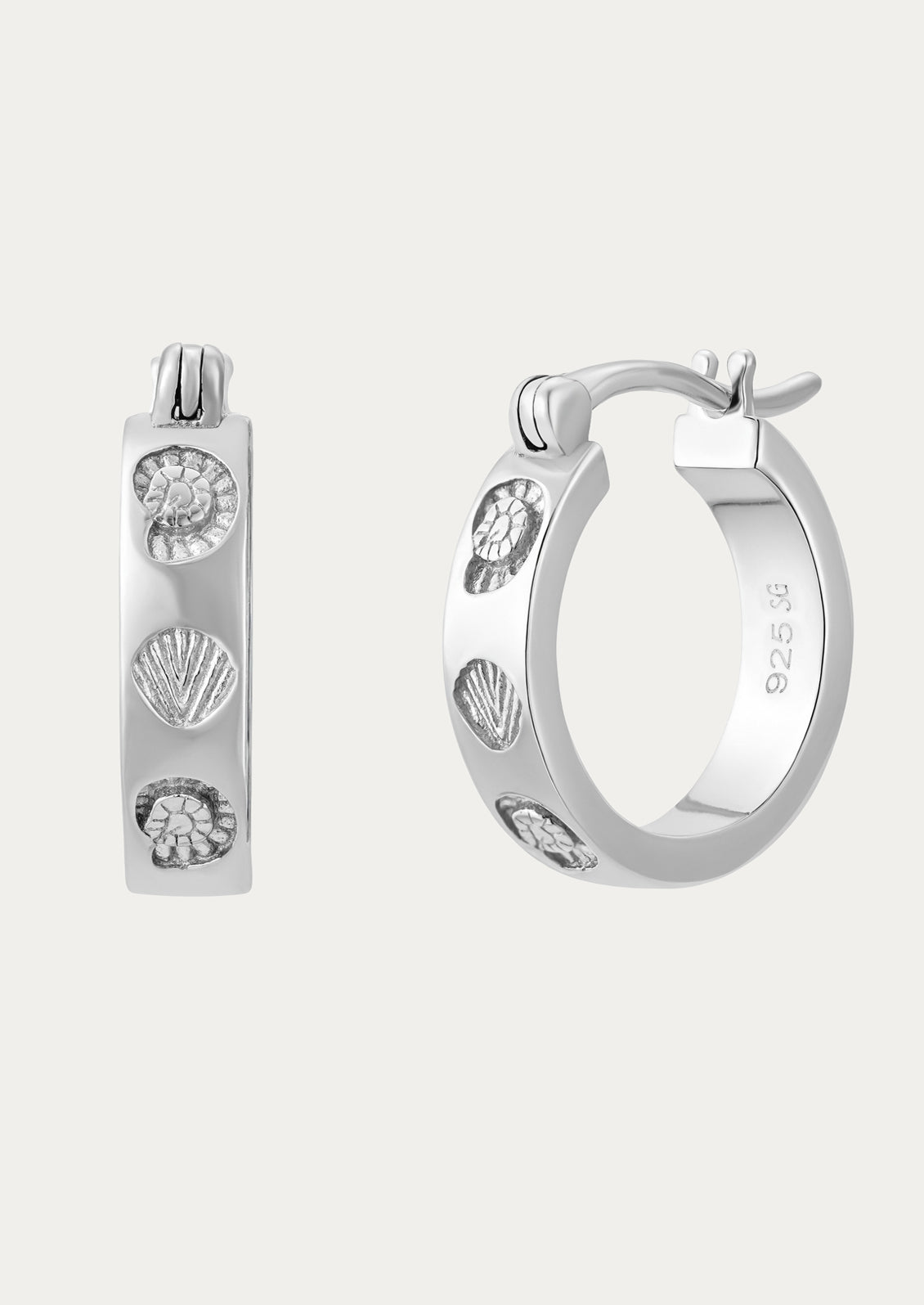 Silver hoop earrings with shell designs on a white background