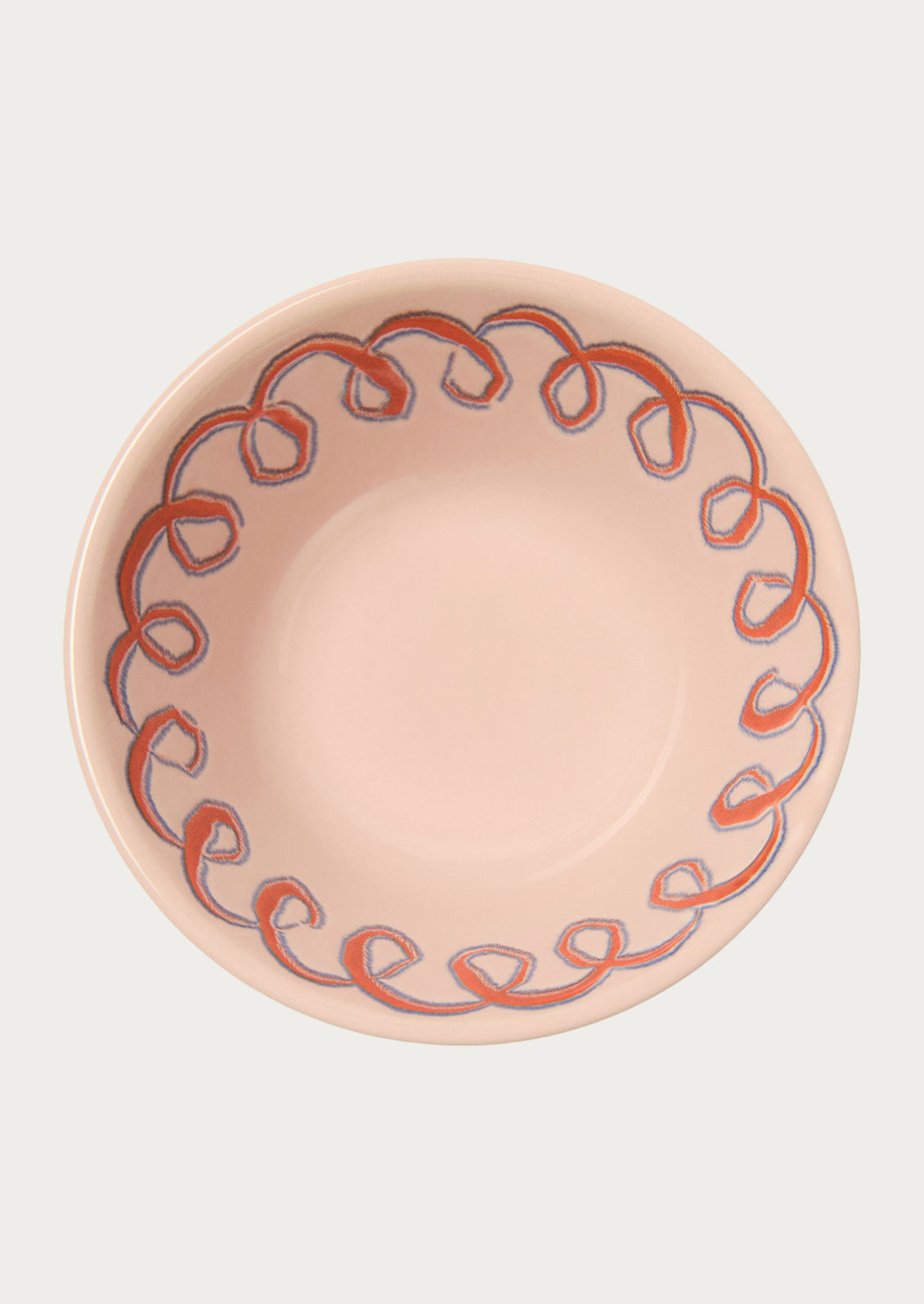 A light pink bowl with a squiggle design along the edge.