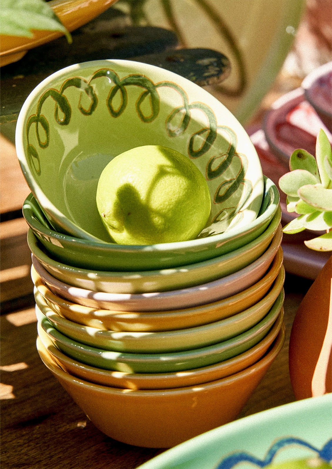 A stack of colorful small ceramic bowls with squiggle design.